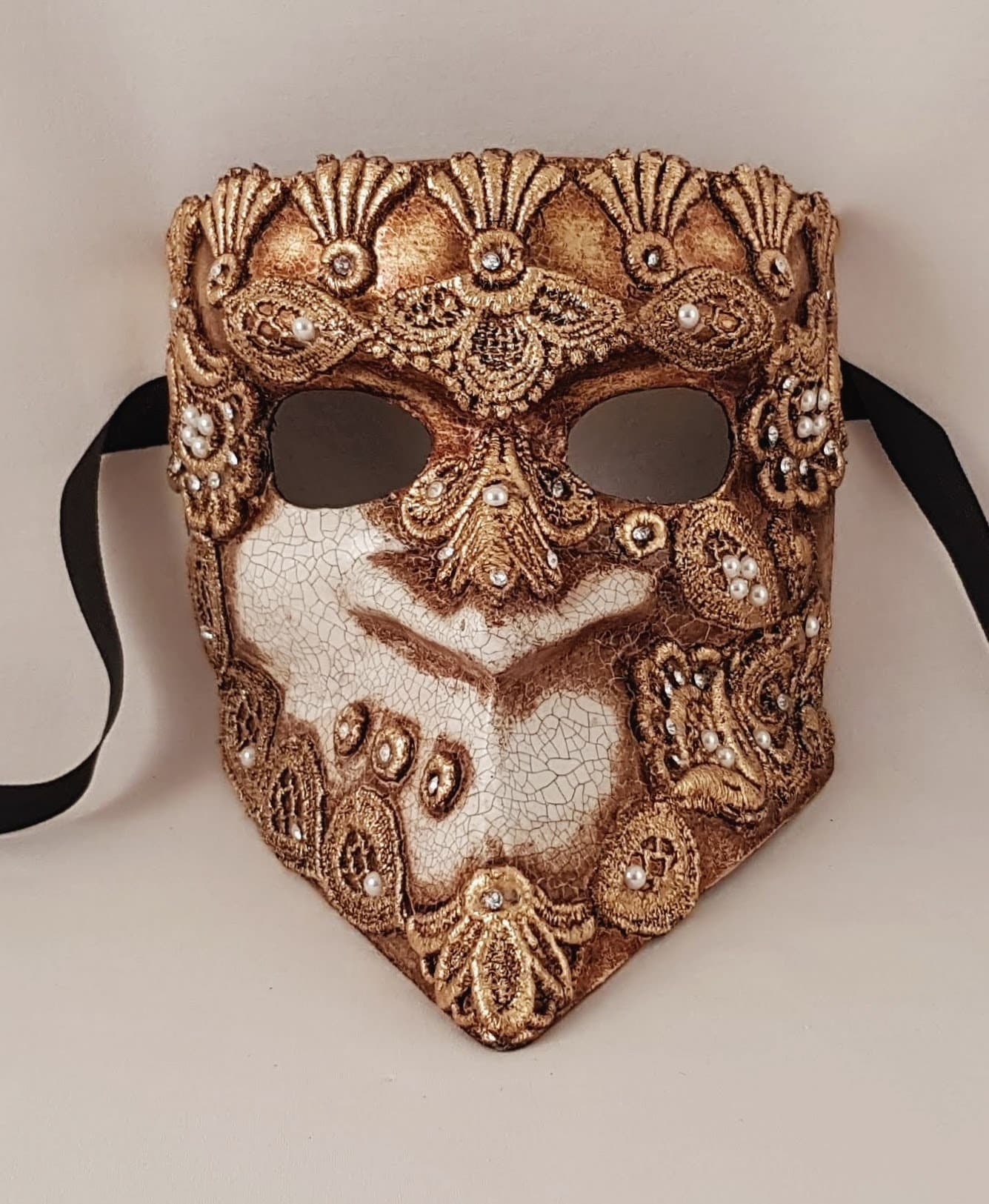 Máscaras venecianas Bauta hechas a mano en Italia en macramè dorado para carnaval y eventos especiales.