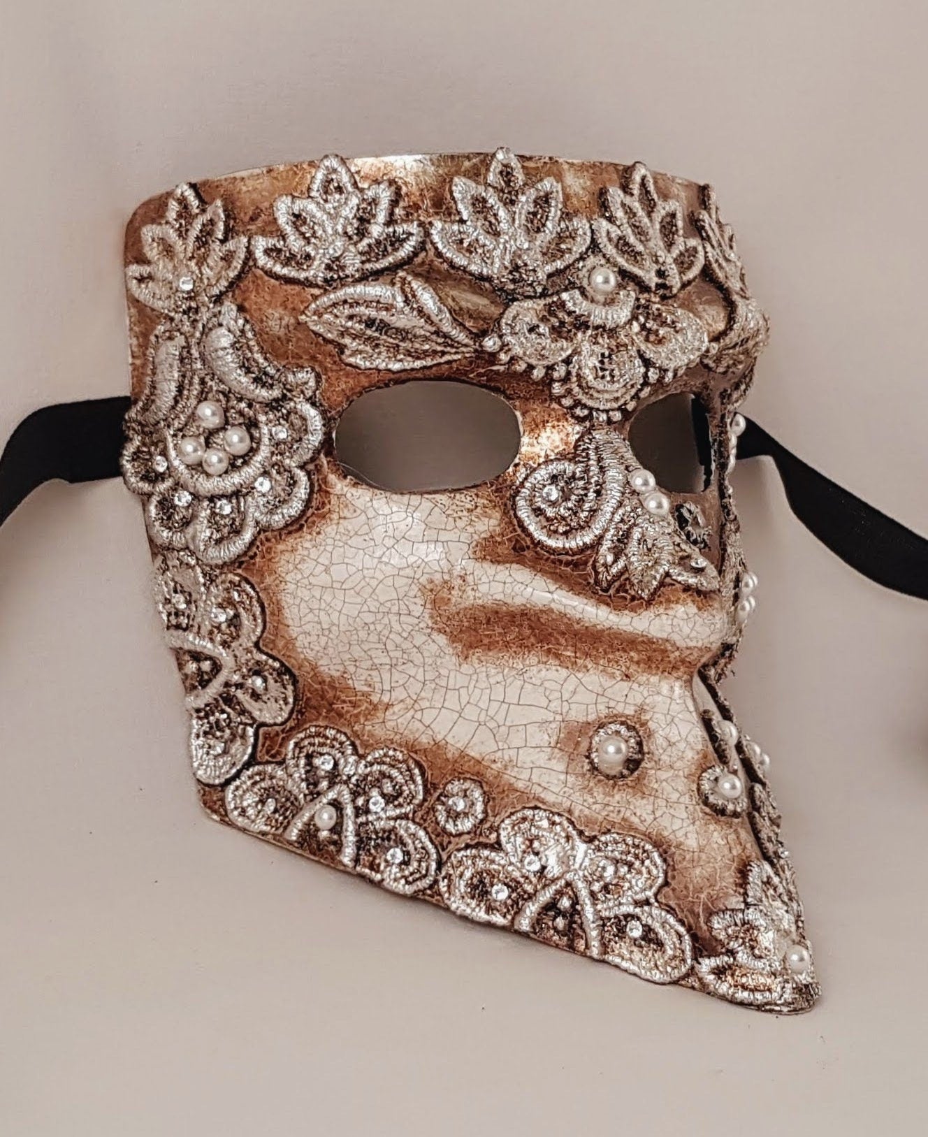Máscaras venecianas Bauta hechas a mano en Italia en macramè plateado para carnaval y eventos especiales.
