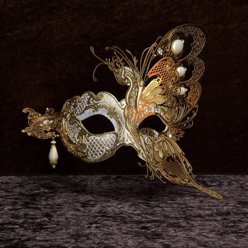 Winged mask in papier-mâché, made by hand. Decorated with fine trimmings, pearls, metal filigree and Swarovski stones. Marcella.